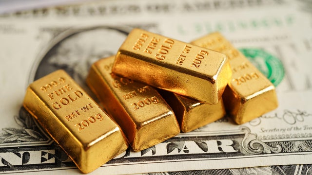 Gold bars on US dollar banknote money, finance trading investment business currency concept. 