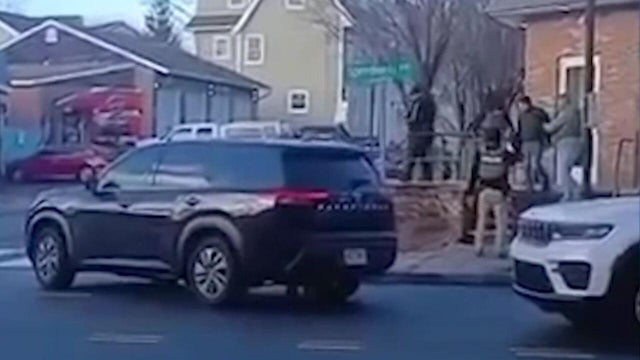 ICE agents detain an individual outside a laundromat 