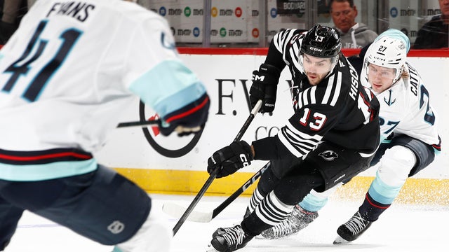 Nico Hischier #13 of the New Jersey Devils controls the puck as Berkly Catton #27 of the Seattle Kraken defends during the second period at Prudential Center on January 14, 2026 in Newark, New Jersey. 
