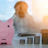 Piggy bank sad with pile coins focus. blur man stressed with Debt and expenses problems, no money to pay, checks, credit card, Broke, mortgage, loan, bankruptcy 