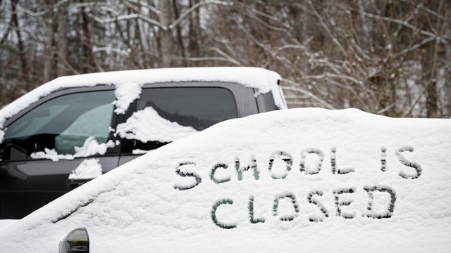 School is closed text, hand writen in fresh snow on an automobile window. 