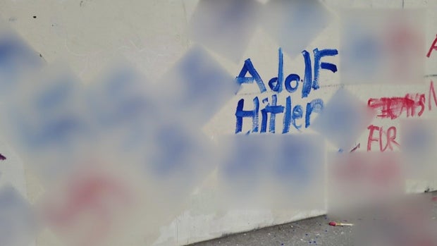 Swastikas and the words "Adolf Hitler" painted on a wall at a playground