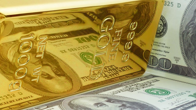 Yellow Gold Ingot Bar with Dollar Bill Reflection. 