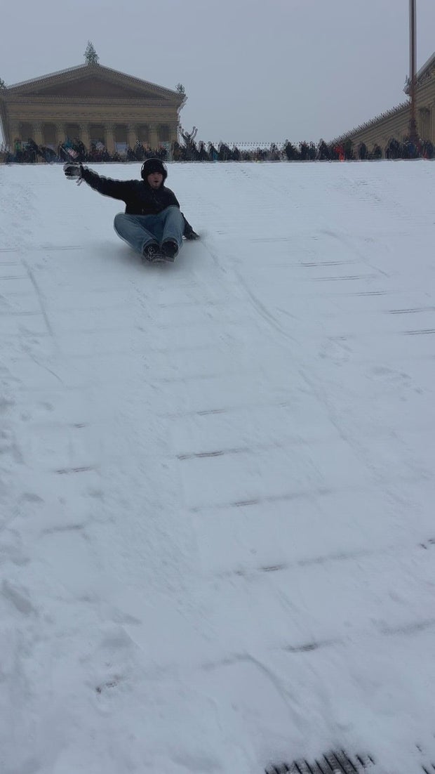 A person sleds down the Philadelphia Art Museum steps 