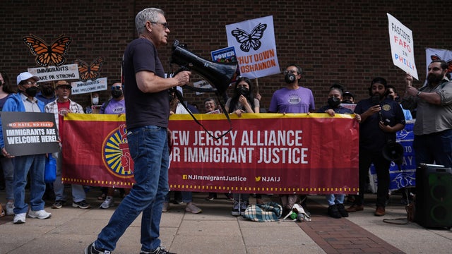 Philadelphia DA LarryKrasner speaks into a megaphone at an immigrant rights event in May 2025 
