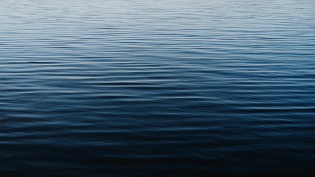 Textured surface of blue water with reflections. Perfect backdrop for your design. 