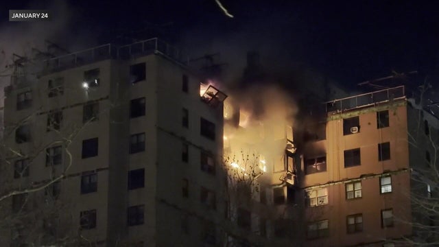 Flames pour out the windows of an apartment building in the Bronx 