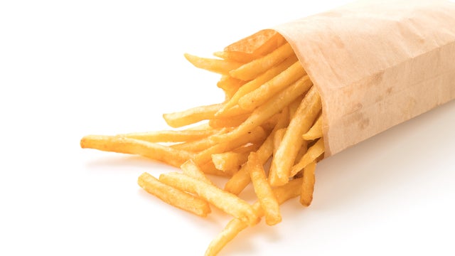 Close-up of french fries against white background 