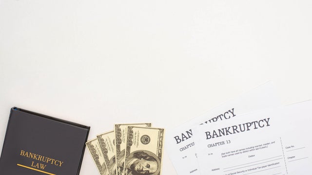 top view of bankruptcy papers, law book and money on white background 