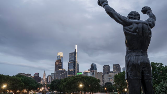 A view of City Hall and the Philly skyline in the background, the Rocky statue at the top of the art museum steps in the foreground 