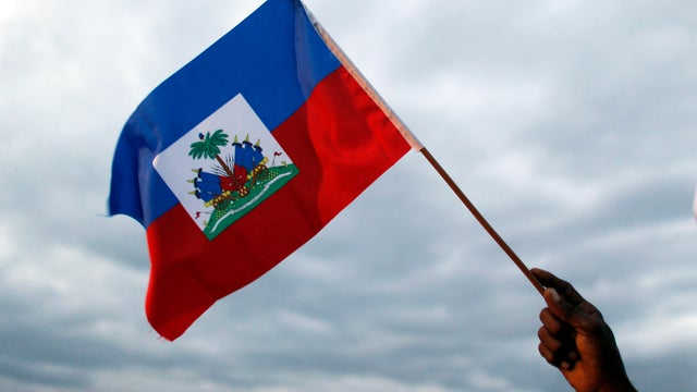 A man waves a Haitian flag at a campaign rally for presidential candidate Maryse Narcisse in Port-au-Prince, Haiti, Friday, Nov. 18, 2016. 