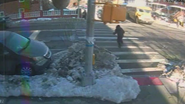 A child runs across a crosswalk as a school bus approaches the intersection