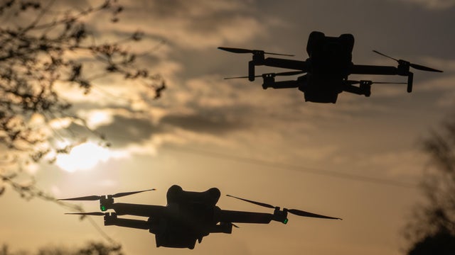 DJI drones fly above the ground on Nov. 8, 2025, in Glastonbury, England. 