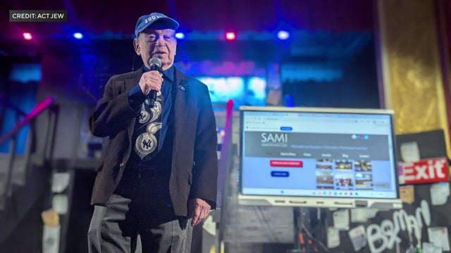 Holocaust survivor Sami Steigmann speaking on stage 