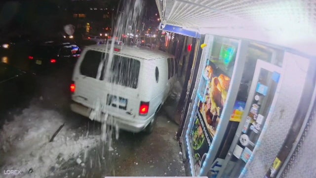 A white van travels down a sidewalk 