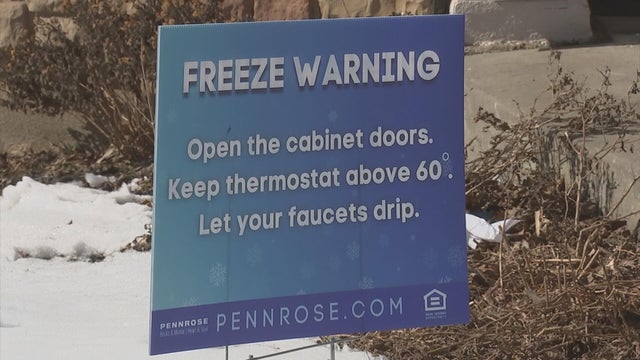 A sign outside the apartment building letting residents know about a freeze warning 