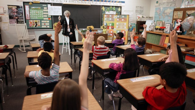 Second Grade Student Raising Hands in Class 