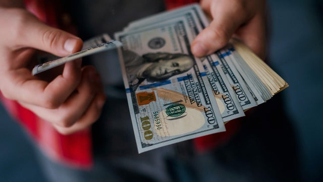 man holding US one hundred Dollar bills 