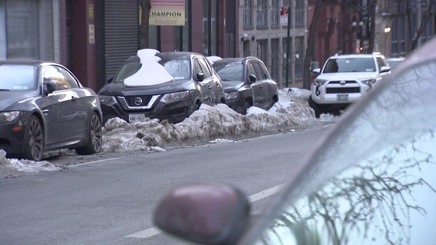 cars parked on street surrounded by snow