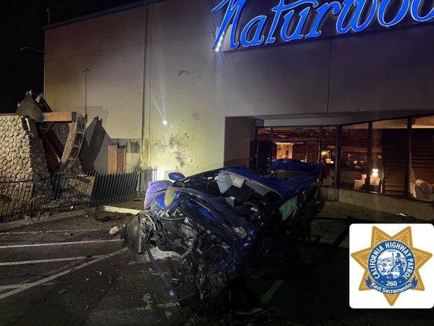 Vehicle with crash damage in front of building