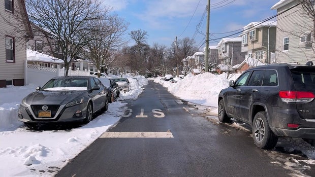 Cleared Staten Island street with snow and parked cars 