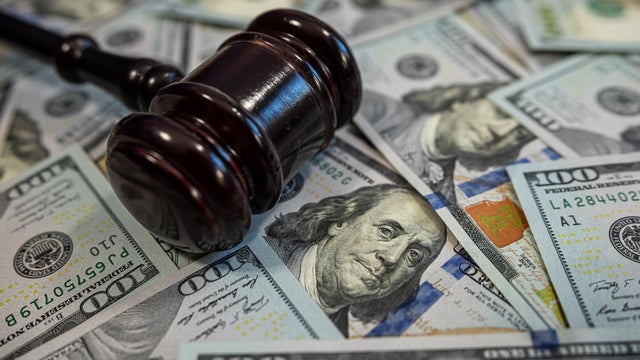 Judge's gavel on pile of US dollar bills &ndash; Concept of justice, corruption, bribery or court fines 