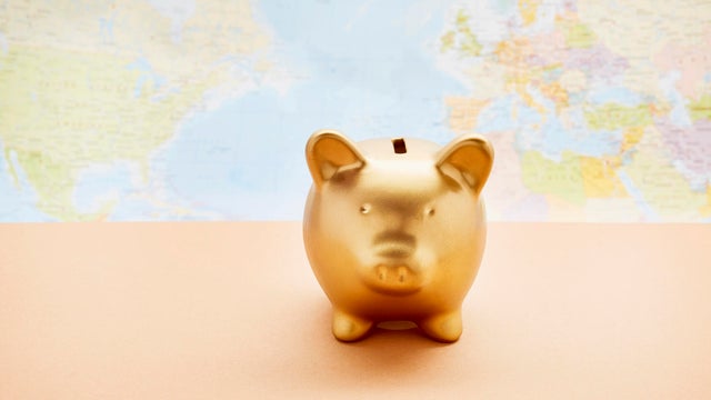 Still life of a golden piggy bank against world map 