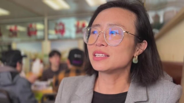 a woman sitting in a restaurant while being interviewed 