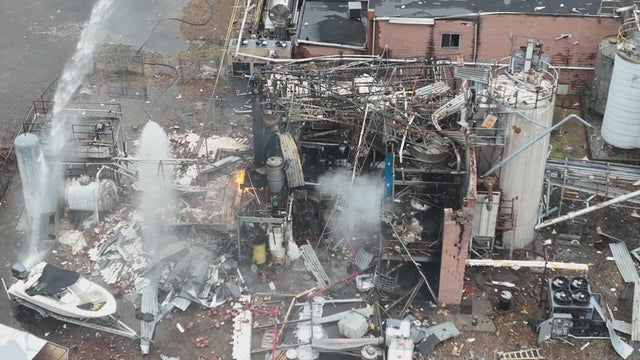 Streams of water and a small fire are seen in this drone image from the site of the explosion 