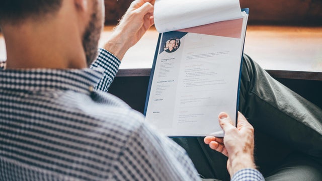 Businessman or HR Manager is reviewing Resume information. 