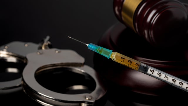 Syringe with gavel and handcuffs. Lethal injection, death penalty and capital punishment concept. 