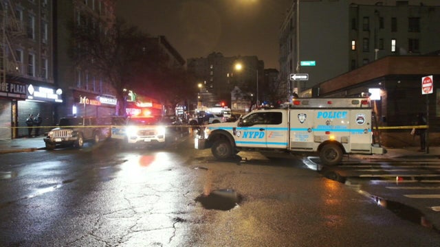 NYPD vehicles and crime scene tape block off an intersection 