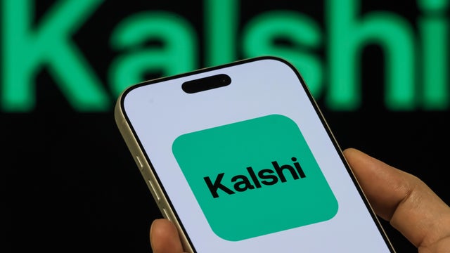 Kalshi App Icon Shown On Smartphone With Kalshi Branding In Background 