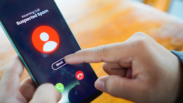 Man receiving an incoming suspected call from unknown caller on her smartphone and rejecting the call 