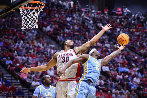 Mason Porter-Brown #6 of the Long Island University Sharks and Tobe Awaka #30 of the Arizona Wildcats reach for a rebound during the second half during the first round of the 2026 NCAA Men's Basketball Tournament held at Viejas Arena at San Diego State Un