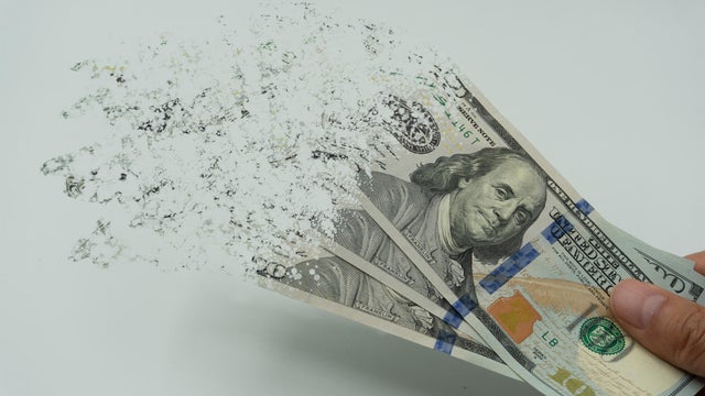 The man's hand holds a 10000 Korean won, which crushes and flutters in the wind. The concept of currency devaluation and economic crisis.collapse, stagnation &middot;economy.Spending and loans,covid 19. 