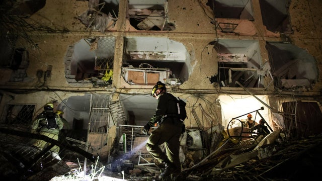 An Israeli soldier uses a torch to inspect the damage after Iranian missile barrages struck Dimona, amid the U.S.-Israel conflict with Iran, in southern Israel 