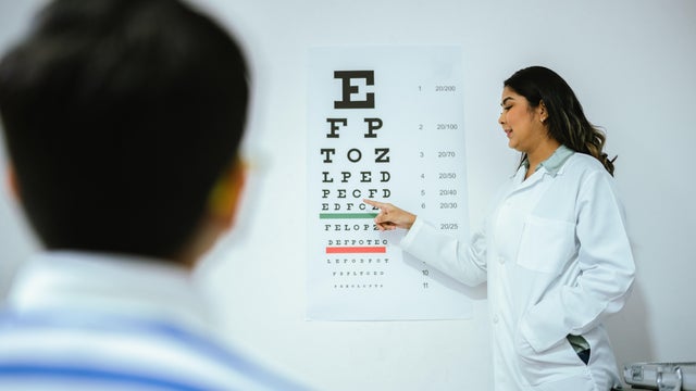 Child boy doing exam looking the eye chart at optics 