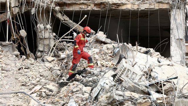 Emergency personnel work at the site of a strike on a residential building amid the U.S.-Israeli conflict with Iran, in Tehran, Iran, March 23, 2026. 