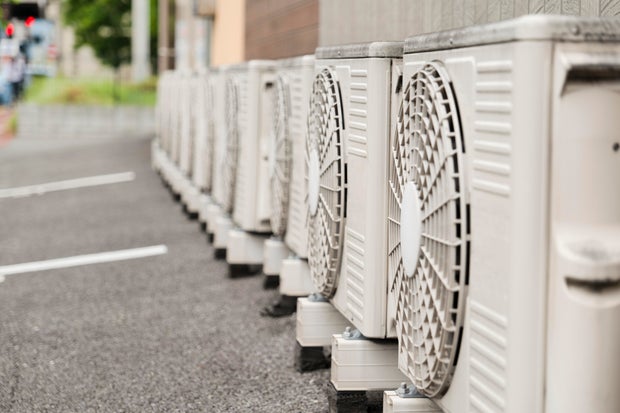 Outdoor Units of Air-Conditioners Lined Up by a Building 