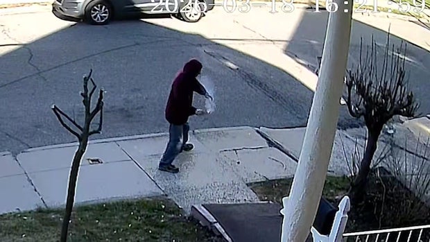 Individual on sidewalk holding smoking device