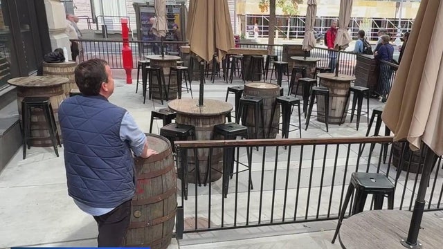A man standing near a restaurant patio 