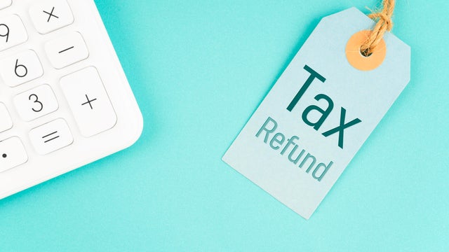 Tax refund on product price tags with calculator on blue background. 