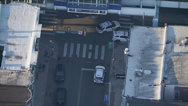 Overhead photo of the scene at 60th and Market streets, police cars and tape are at the intersection 