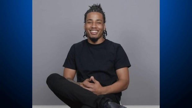 A man sits in a chair for a photograph 