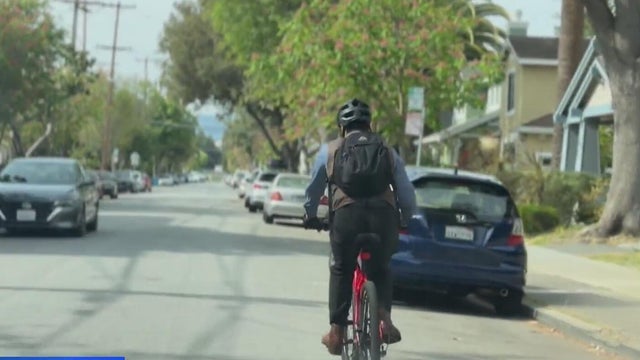 A person riding a bike on a residential street 