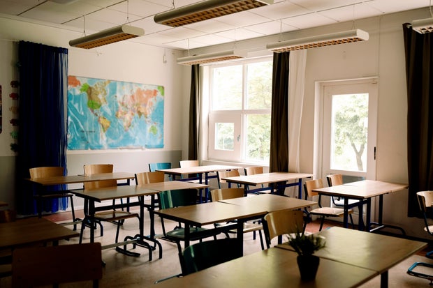 Desks and chairs arranged in classroom at high school 