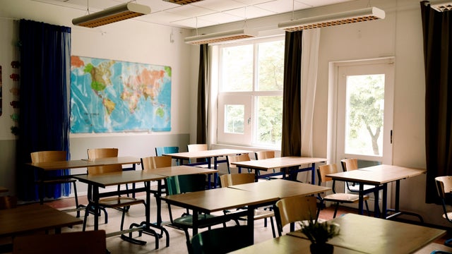 Desks and chairs arranged in classroom at high school 
