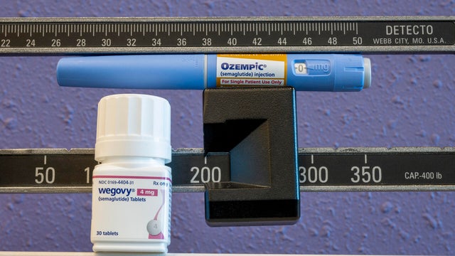 Still life of the new Wegovy 4mg semaglutide tablets with Ozempic injectable pen and weight scale 