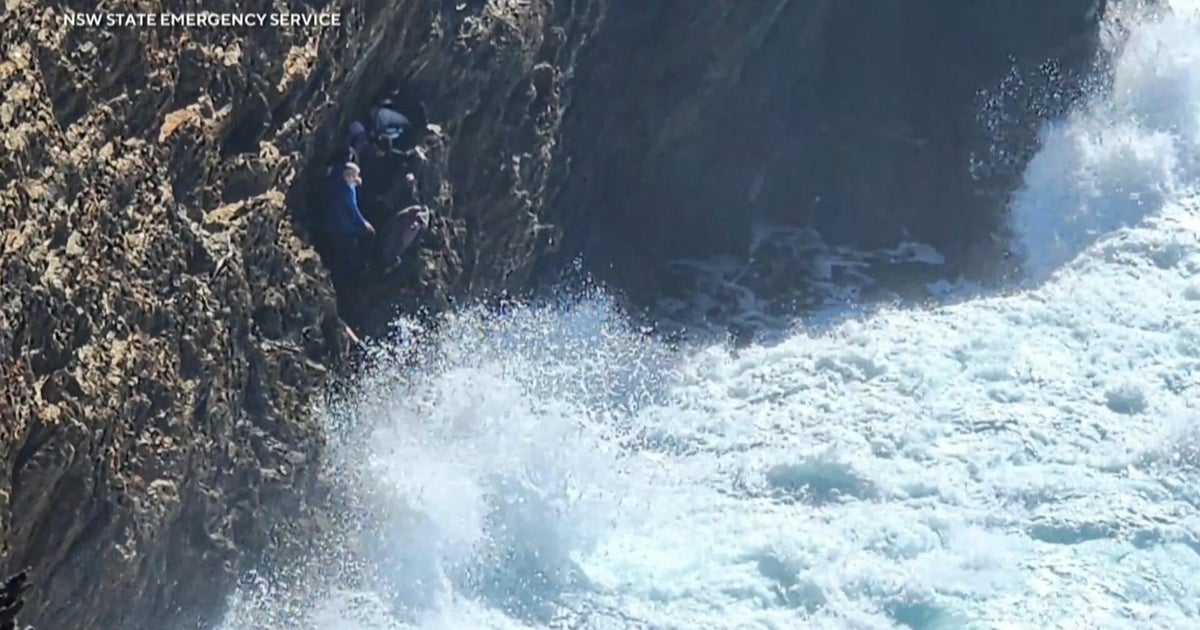 Tourists rescued from cliff in as huge waves inched closer
